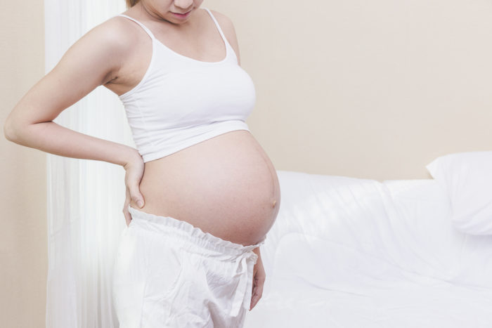 maux de dos pendant la grossesse à l'aide d'un coussin chauffant